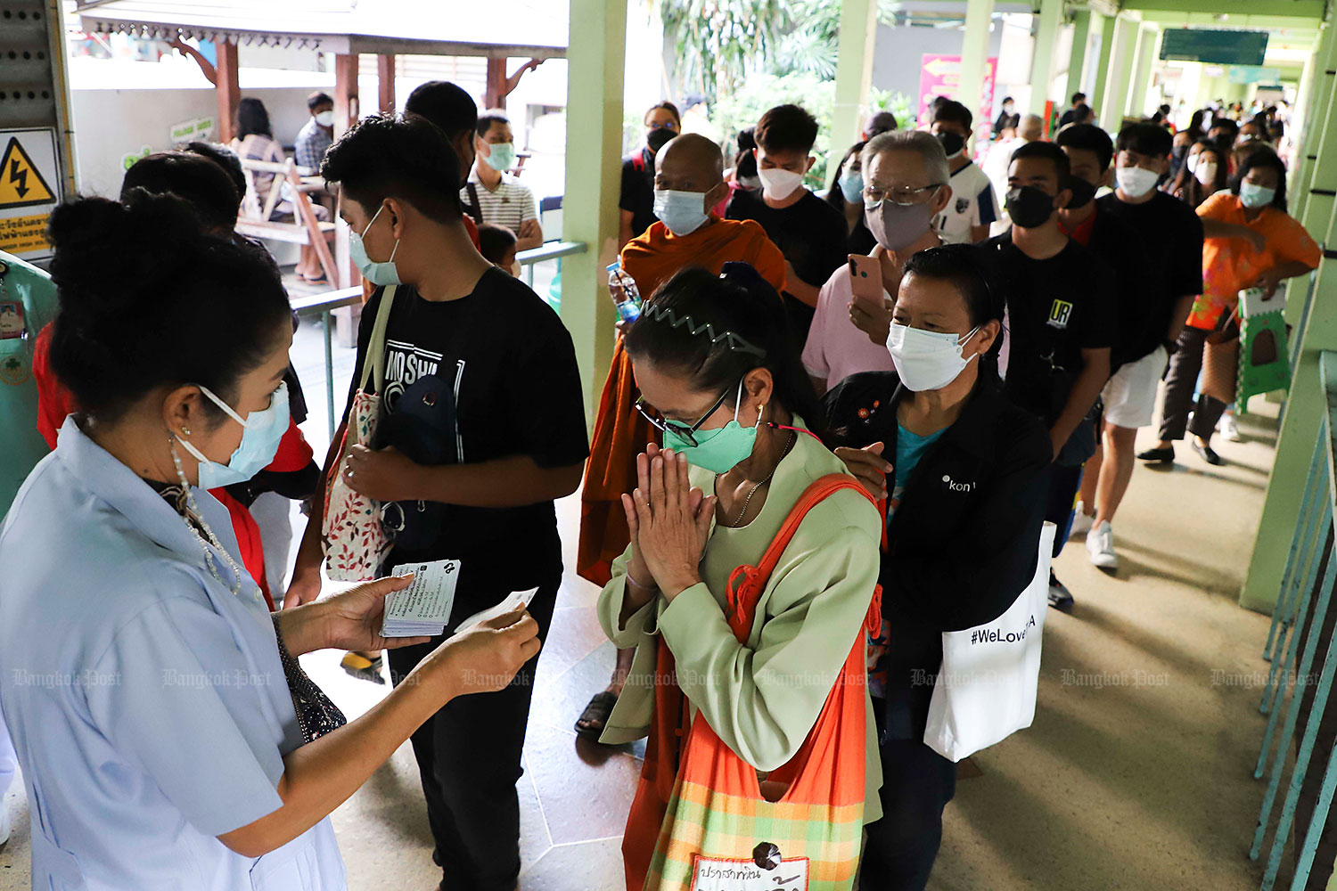 Just the ticket: People get in line to pick up queue cards for Covid-19 vaccinations at Pathumthani Hospital in Pathum Thani’s Muang district yesterday. A Department of Mental Health survey has linked stress caused by the pandemic to rising suicide rates. (Photo: Pattarapong Chatpattarasill)