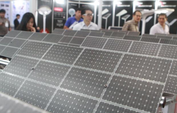 Attendees gaze at solar panels during Asean Sustainable Energy Week in June. Panel prices are now affordable for many companies and consumers. Somchai Poomlard