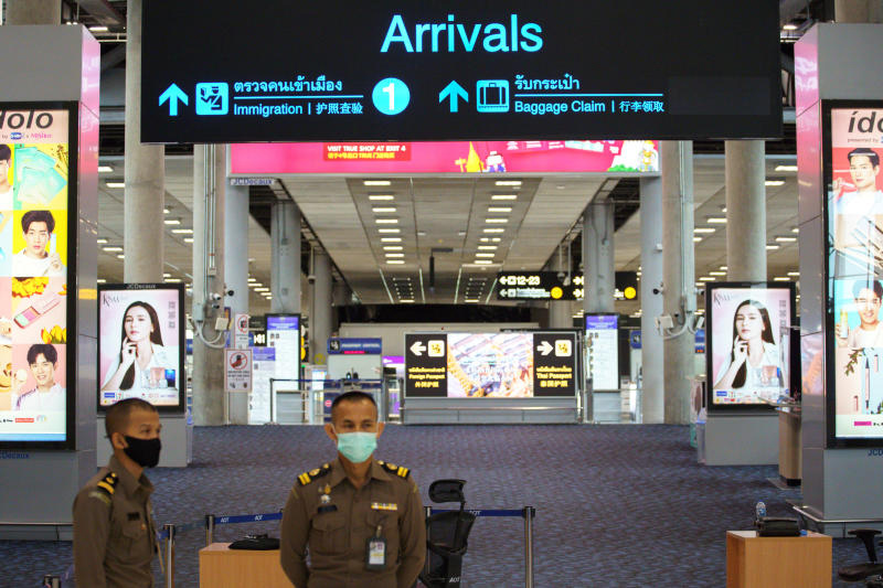 Immigration officers stand in front of an empty arrivals hall at Suvarnabhumi airport on June 3, 2020. (Reuters photo)