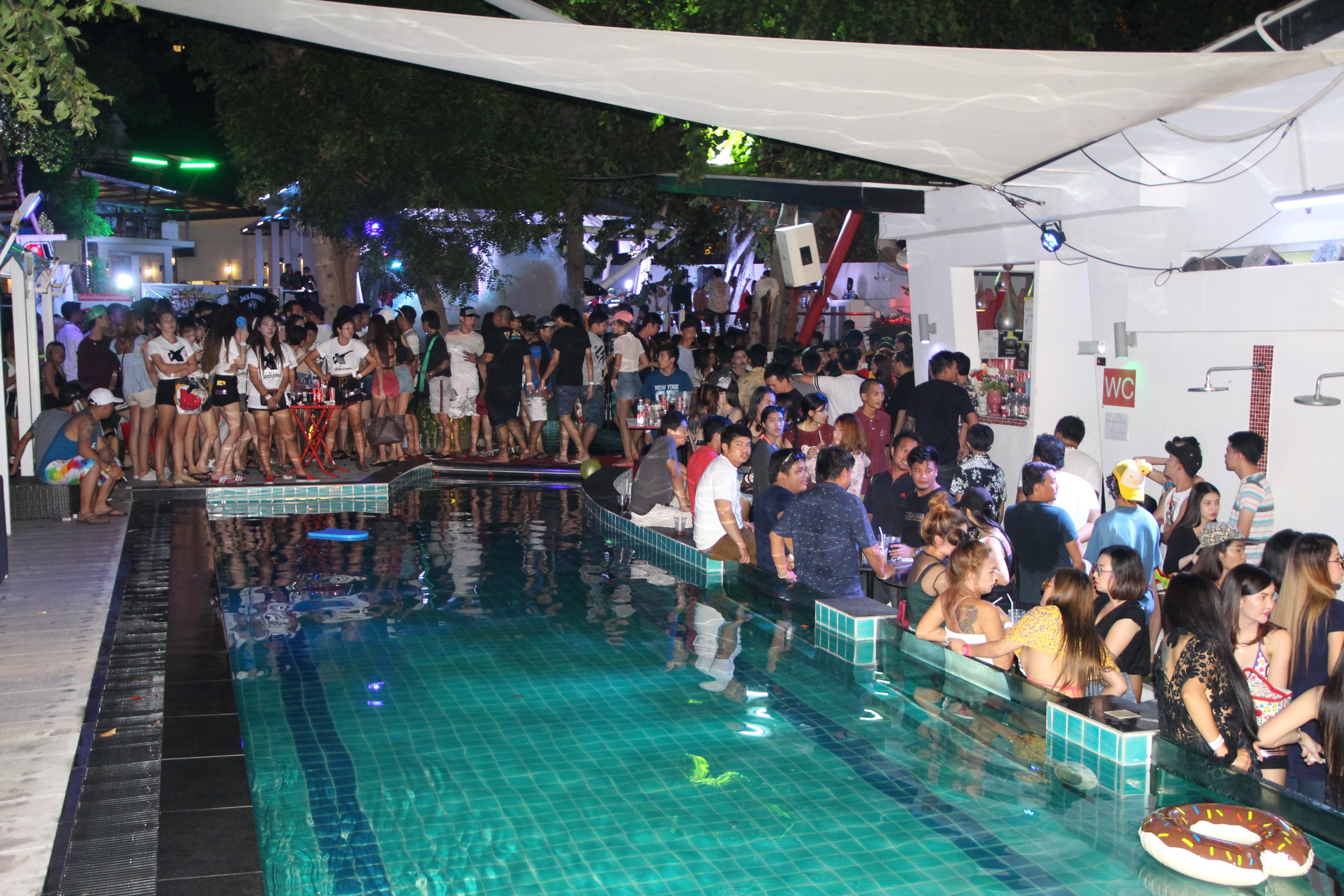 Partygoers wait by a pool in Pattaya after authorities raided the venue on Saturday night. (Photo by Chaiyot Pupattanapong)