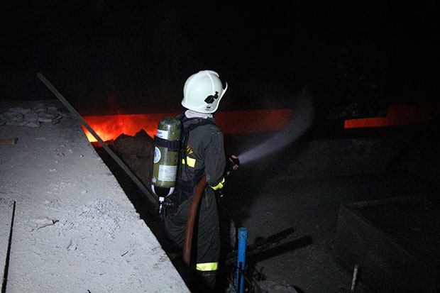 A fireman spray water into the basement of one of three buildings under construction at Le Bali Hotel in the early hours of Saturday. No casualties were reported. (Photo by Chaiyot Pupattanapong)