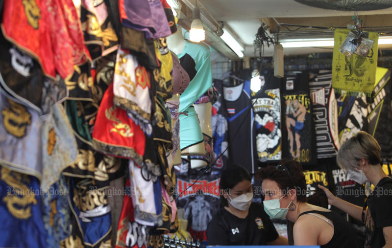 Tourists shop for clothes on Saturday at Chatuchak Market, which is allowed to reopen in the latest easing of Covid-19 restrictions. However, only about 10% of vendors resumed trade. (Photo: Apichart Jinakul)