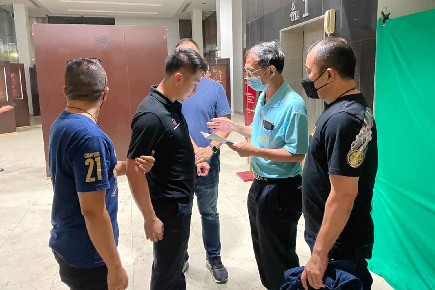 Huang Tianyong, 33, second left, is arrested at a parking lot in Bang Khen district on Sunday. (Police photo)