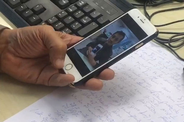 A police officer shows the image of Prasit Ditthachina, who is under an arrest warrant for abducting a Chinese tourist., on a phone. (Photo by Sutthiwit Chaiyutvorakan)