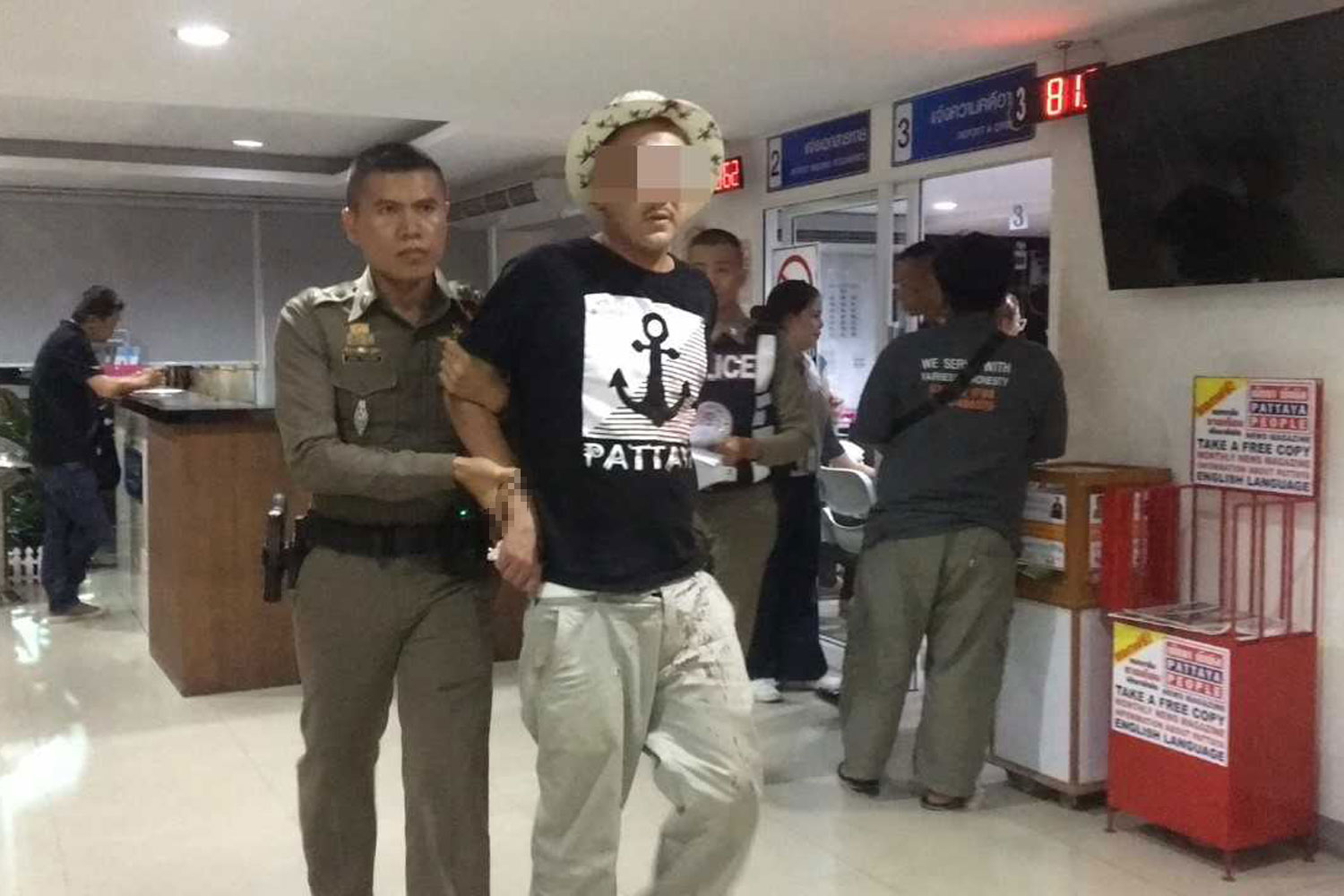 A policeman brings Meriem Laurent, 40, to the Pattaya police station after he tried to steal a Huawei smartphone at a shopping centre on Wednesday night. (Photo by Chaiyot Pupattanapong)