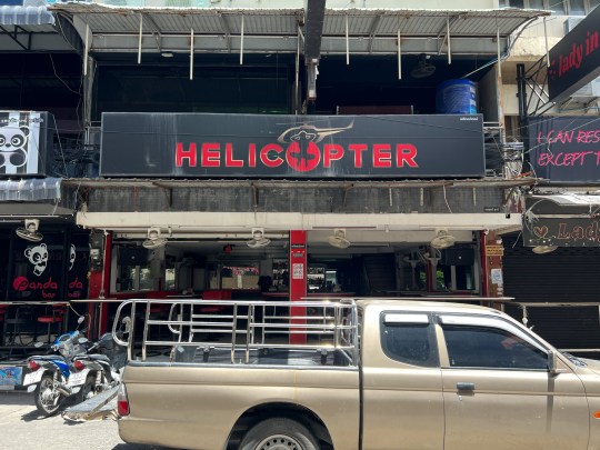 A British tourist is in a coma after a bouncer football kicked him in the head in Thailand. The holidaymaker and two friends had been drinking at the notorious Soi 6 road in red-light city Pattaya when they began arguing over the bill on Friday evening. They claimed that the bar had tried to scam them by inflating the receipt - a common trick in the city - sparking angry scenes with the assembled hookers at the Helicopter Bar (PICTURED). Three security guards intervened and attacked two of the men - one in a grey shirt and one in a white shirt - knocking them both to the ground. Footage shows the tourist lying on the ground while raising his hands pleading for them to stop. However, one of the guards then takes a run-up and kicked his head at full force. The victim was lifeless on the ground for several minutes.??????PACKAGE: Video, pictures, text