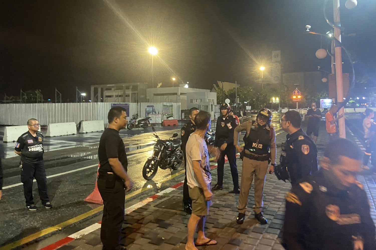 Police talk to the British man after escorting him down from an abandoned high-rise residential complex in Pattaya, Chon Buri, early Thursday morning. (Photo: Chaiyot Pupattanapong)